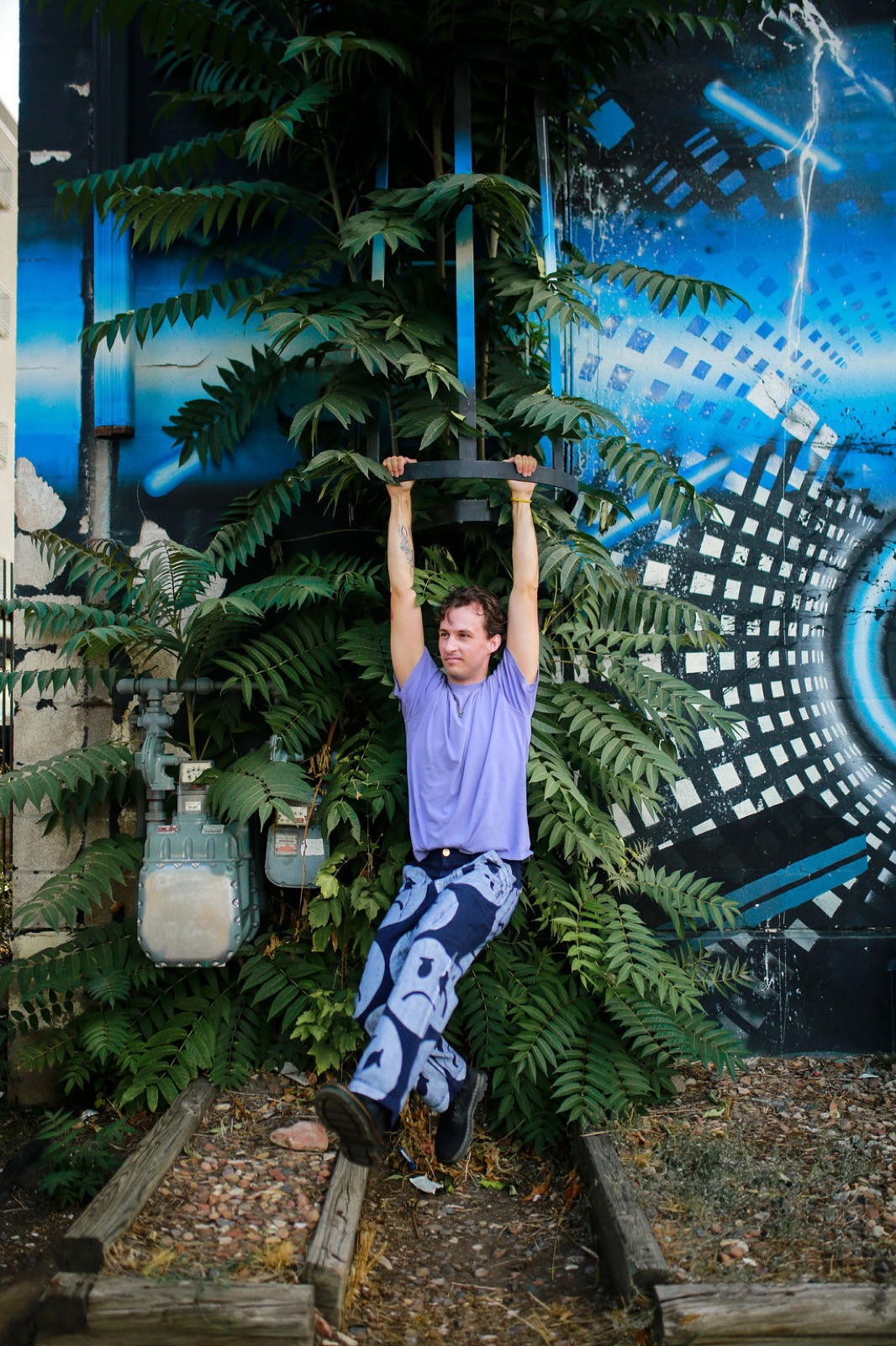 Mick Jeets hanging from a bar in front of a mural